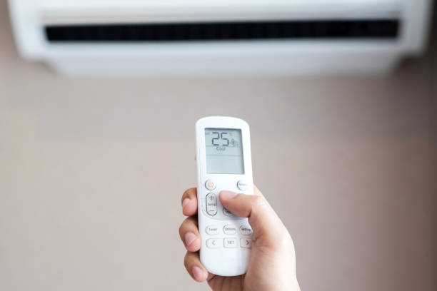 fernbedienung der klimaanlage bei 25 grad celsius, um stromkosten zu sparen - electric fan women wind beautiful stock-fotos und bilder