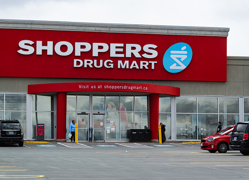 April 11, 2020 - Halifax, Canada - Customers wait to enter the Shoppers Drug Mart drugstore located on Lacewood Drive, Clayton Park.  The drugstore chain is offering reduced hours and in-store social distancing practices during the ongoing COVID-19 pandemic.