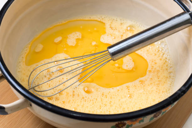 istock Mixed eggs with oil in the bowl with wire 1220134253