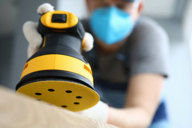 Male handy man hold yellow grinder with disc sander in hand closeup Male handy man hold yellow grinder with disc sander in hand closeup background. Professional education concept. sand paper stock pictures, royalty-free photos & images