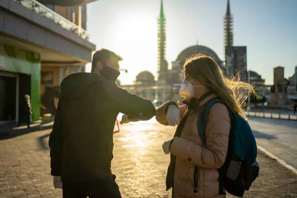 Photo of Two friends greeting during pandemic