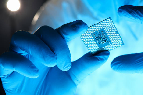 istock Close-up gloved hands holding detail microchip 1220136527