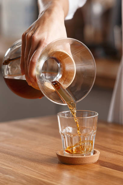 istock pour coffee into a glass on a wooden table 1220139351