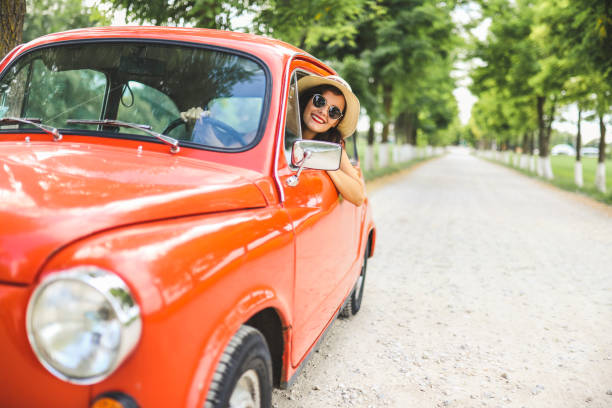 Woman driving vintage car Young fashion woman driving red vintage car vintage car stock pictures, royalty-free photos & images