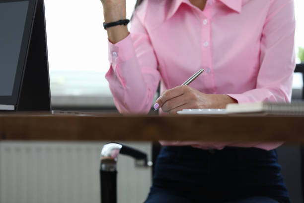 woman sitting office takes notes during discussion - people strength leadership remote imagens e fotografias de stock