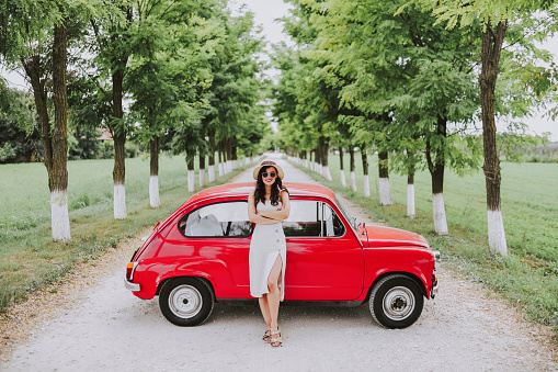 Fashion young woman and her red vintage car