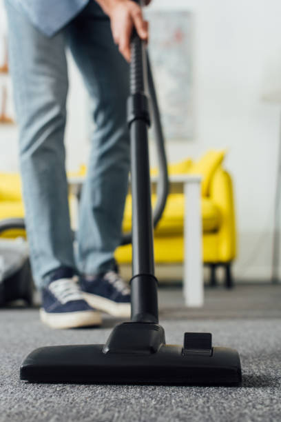 istock Selective focus of man using vacuum cleaner in living room 1220142252