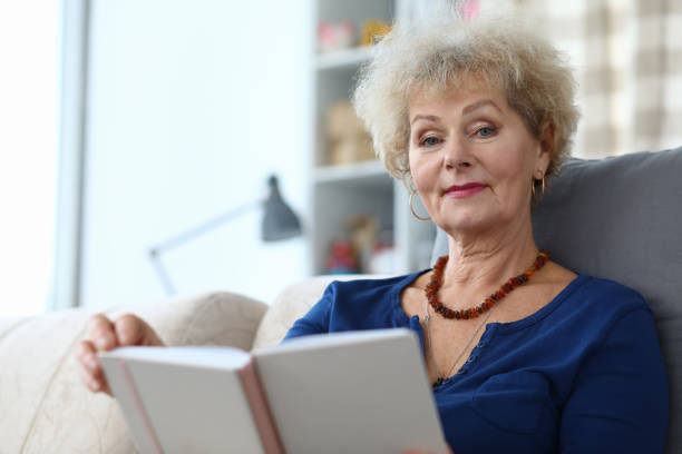 istock Elderly woman self-isolation reading book at home 1220142406