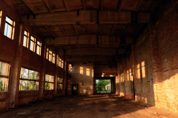 istock A large abandoned industrial building is lit by light from the windows. Large red brick building. 1220143514