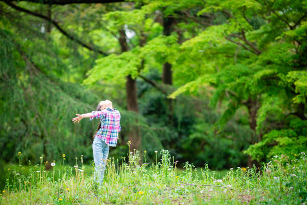 istock Girl with open arms in the forest 1220143695