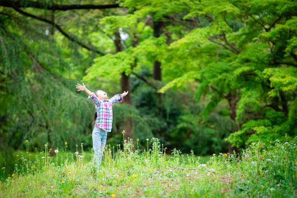 istock Girl with open arms in the forest 1220143757