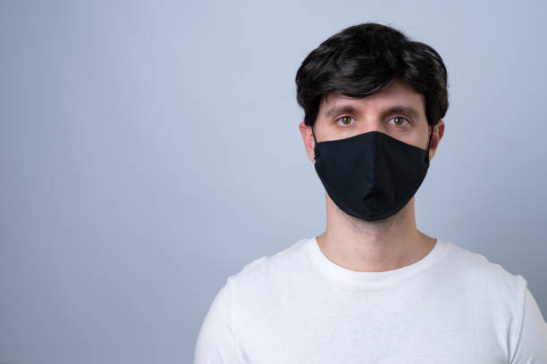 istock Man in a black medical mask, isolated on a gray background 1220143945