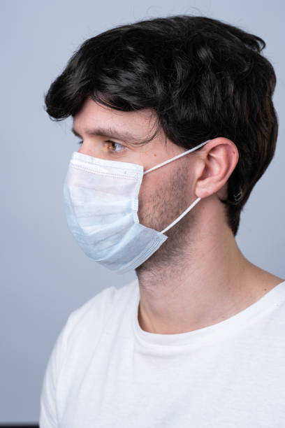 istock Man in a medical mask, isolated on a gray background 1220144431