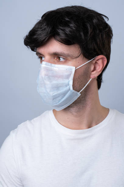 istock Man in a medical mask, isolated on a gray background 1220145484