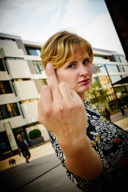 istock young woman showing her middle finger 1220145926