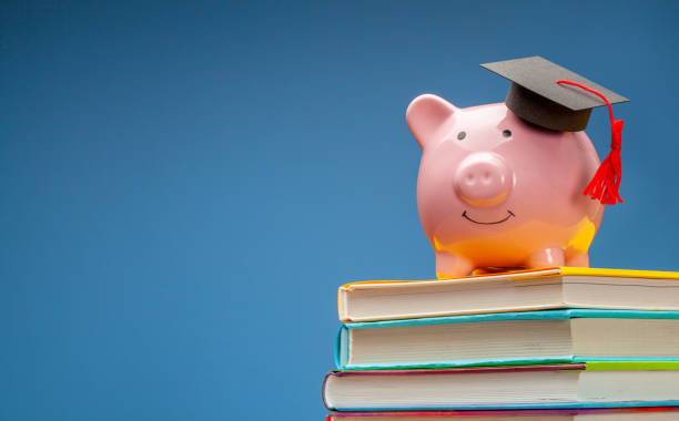 istock Piggy bank in graduate hat on stack of books 1220146192