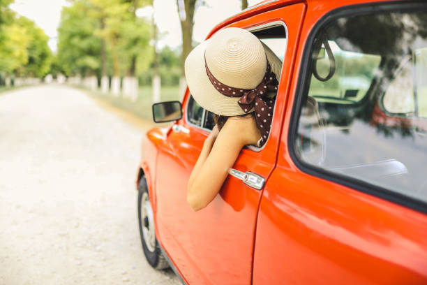 istock Woman driving vintage car 1220146248