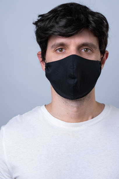 istock Man in a black medical mask, isolated on a gray background 1220146367