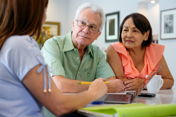 Concerned Hispanic senior couple listening to financial advice Worried Latin American seniors meeting with female financial advisor in their home and learning news of investment results. florida real estate house home interior stock pictures, royalty-free photos & images