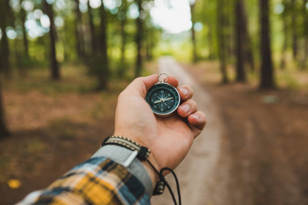 istock compass in man hand hiking by forest trail 1220148115