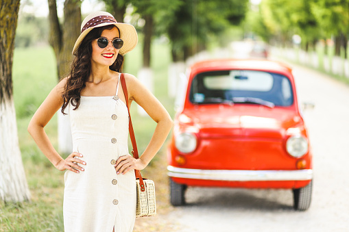 Portrait of fashion young woman and her red vintage car