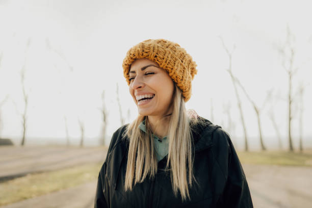 Close-Up Of Smiling Young Woman Covering Eyes With Knit Hat
