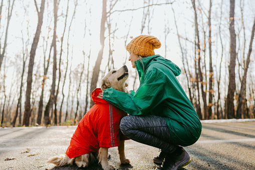 Photo of active young woman and her dog outdoors
