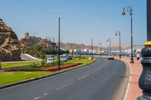 Muscat, Oman - March, 17. 2019 - Al Bahri Road im Muscat along the bay of the Sultan Qaboos Road. The beautiful colorful promenade with a lot of patterns in the bottom is a popular walk for locals and tourists. On the hill the Mutrah Fort