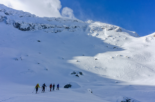 Group of skiers touring uphill on a sunny day