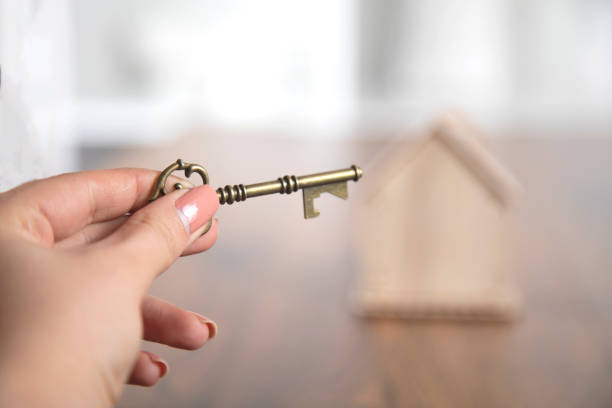 istock woman hand key with house on table 1220154580