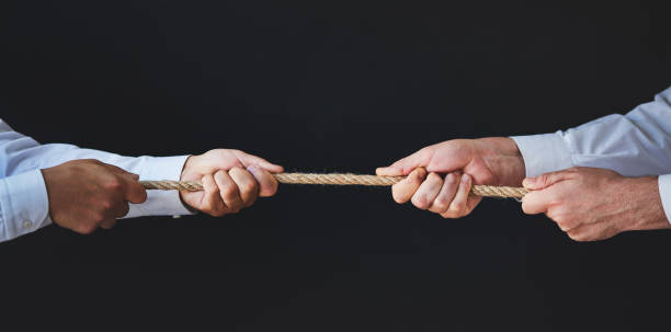 istock Corporate business people pulling on a rope during tug of war 1220155890