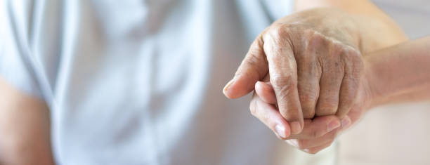 Caregiver, carer hand holding elder hand in hospice care background. Philanthropy kindness to disabled old people concept.Happy mother's day. Caregiver, carer hand holding elder hand in hospice care background. Philanthropy kindness to disabled old people concept.Happy mother's day. hospice photos stock pictures, royalty-free photos & images