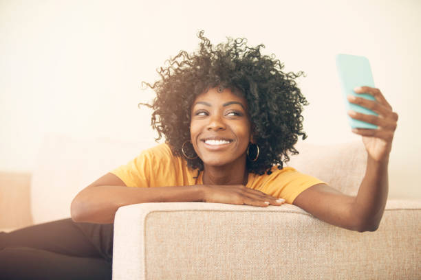 istock Happy young woman having fun at home with mobile phone 1220156485