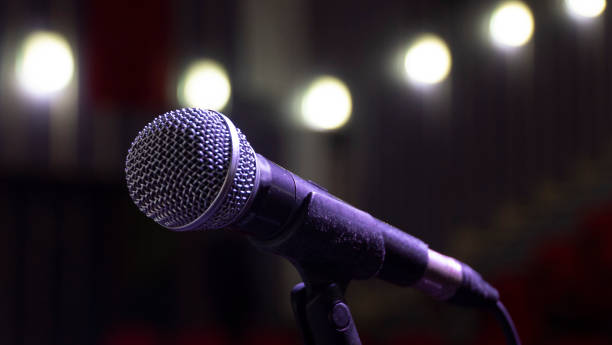 istock Microphone on abstract blurred of speech in seminar room or speaking conference hall light, Event Background 1220156971