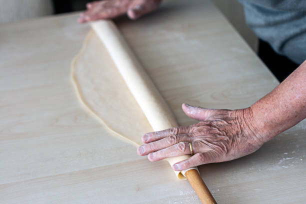 istock Hands baking dough with rolling pin on wooden table 1220158109