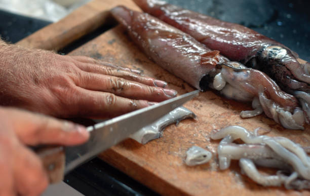 man cutting squids