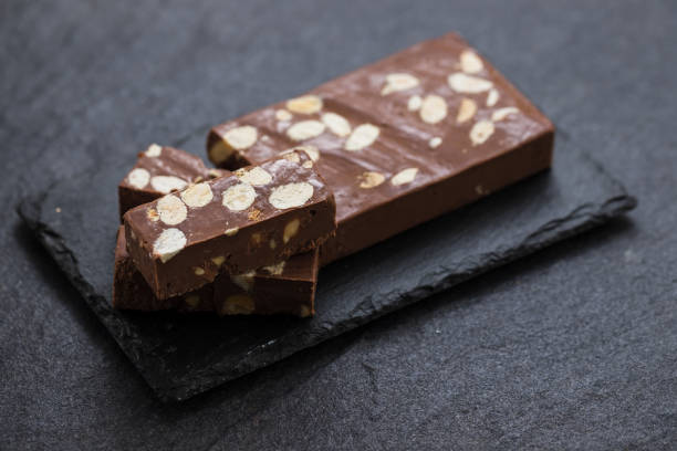 chocolate turron on ceramic background - torrone fotografías e imágenes de stock