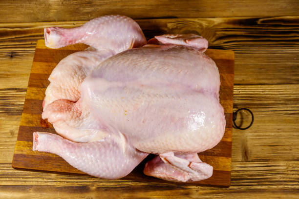 istock Raw whole chicken on a wooden table. Top view 1220159596