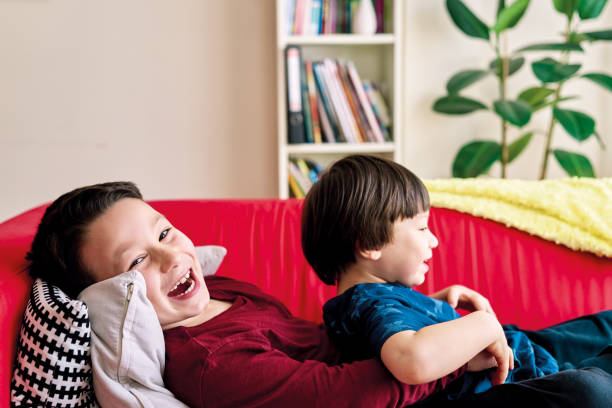 istock Happy children playing on sofa together 1220159740