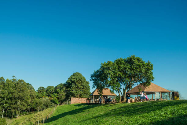 Pardinho, Brazil - June 20, 2019. People taking pictures and having fun on top of hill covered by green lawn in an estate near Pardinho. A small rural village in the countryside of Sao Paulo State.