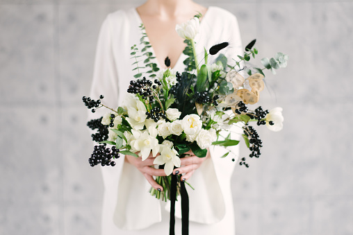 Beautiful modern wedding bouquet in the hands of the bride. black and white color scheme.