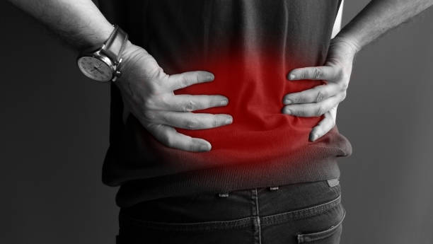 man suffering from backache,Lower back pain man holding his back in pain. backache - black and white lower back pain stock pictures, royalty-free photos & images