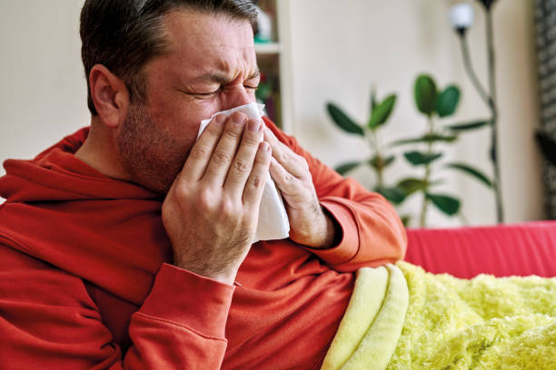 istock 30-39 years old man feels sick and bad. He lying down on sofa with blanket. 1220164661