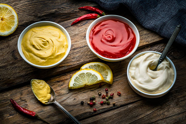 istock Ketchup, mustard and mayonnaise on rustic wooden table 1220165363