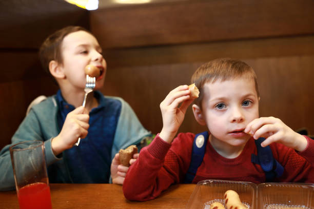 istock Two boys eating sausages 1220165369