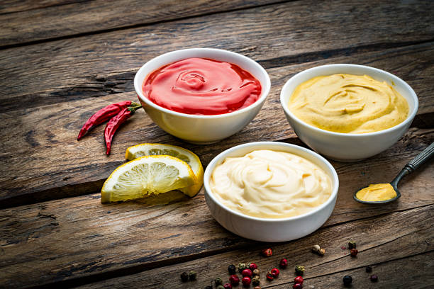 istock Ketchup, mustard and mayonnaise on rustic wooden table 1220165403