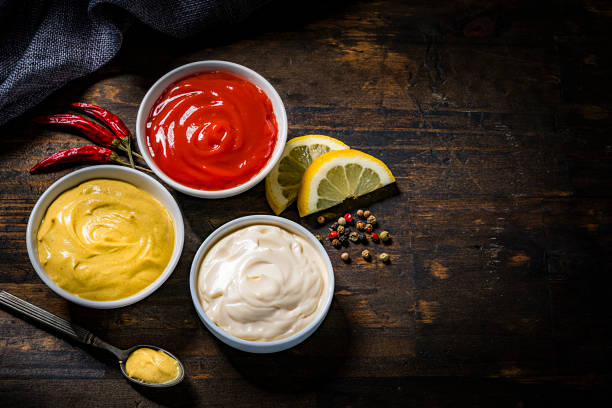 istock Ketchup, mustard and mayonnaise on rustic wooden table 1220165411