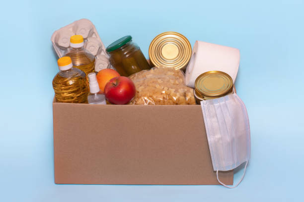istock Food in a donation cardboard box, isolated on blue background,copy space. Coronavirus Relief Funds and Donations.Charity donations. Making Donations To Food Bank 1220166475
