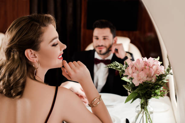 istock selective focus of elegant man looking at attractive woman while sitting at served table in plane 1220167461
