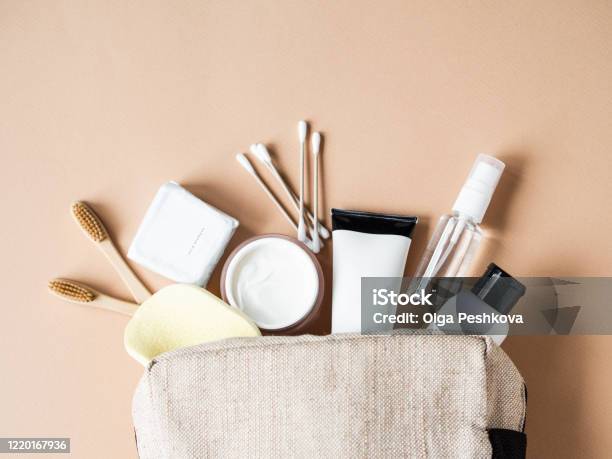 Travel Cosmetic Bag With The Necessary Means To Care For Womens Skin Cosmetics Dry Shampoo Cotton Buds Toothbrushes Next A Cosmetic Bag On A Beige Background Top View Stock Photo - Download Image Now